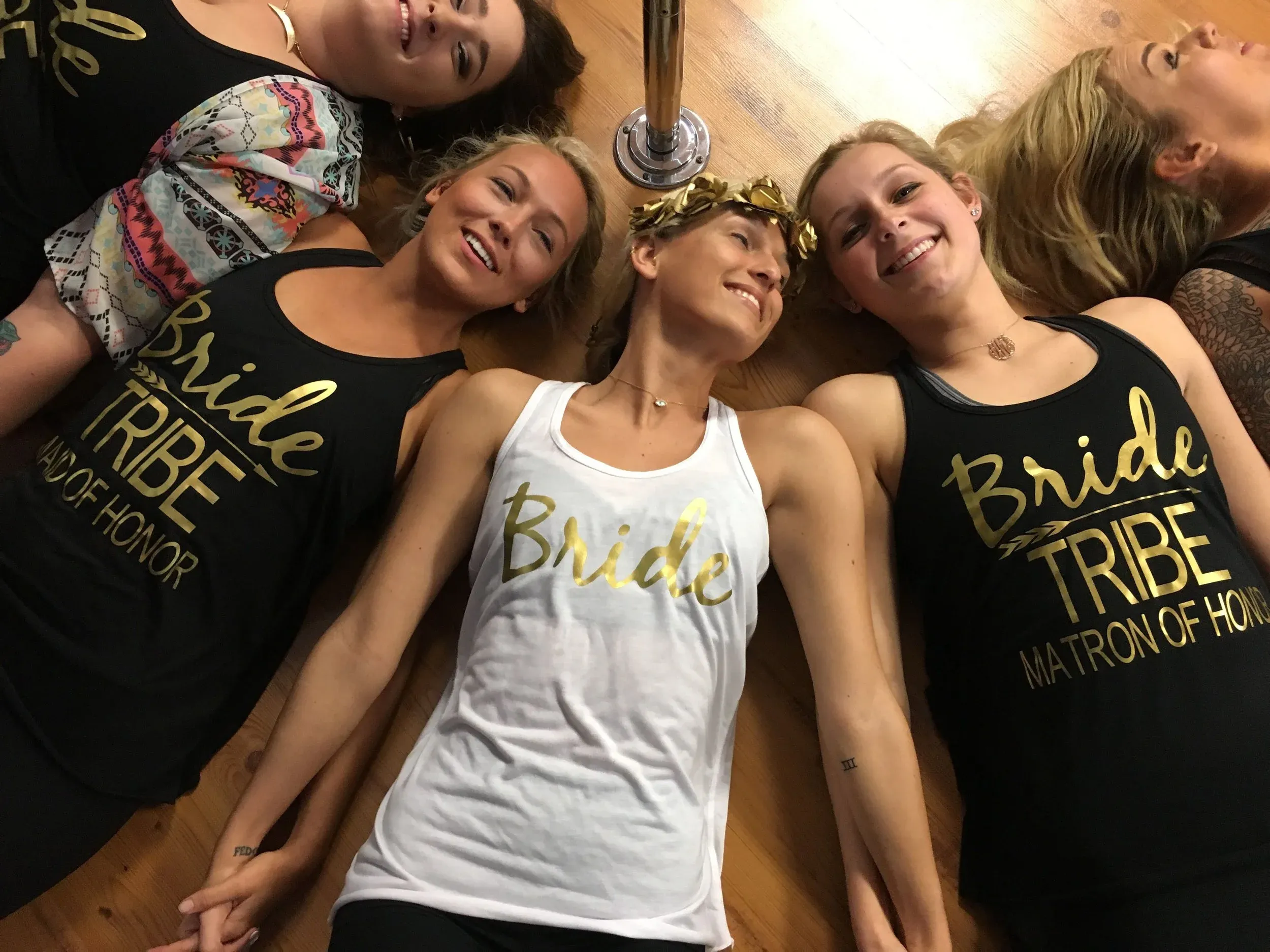 Bride tribe in matching outfits celebrating a bachelorette party at Pole Fitness Studio